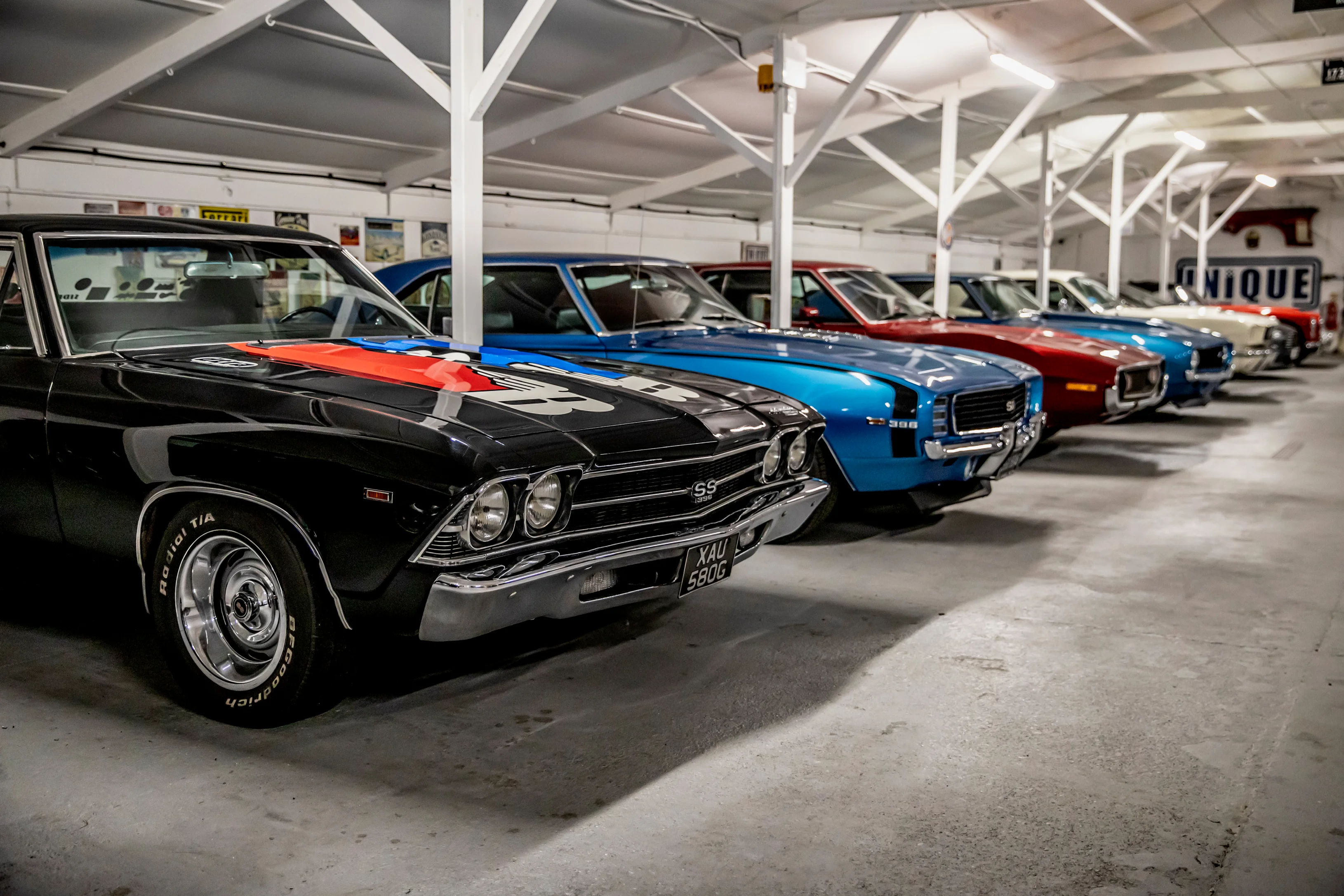 A row of classic muscle cars inside the Paddock Club